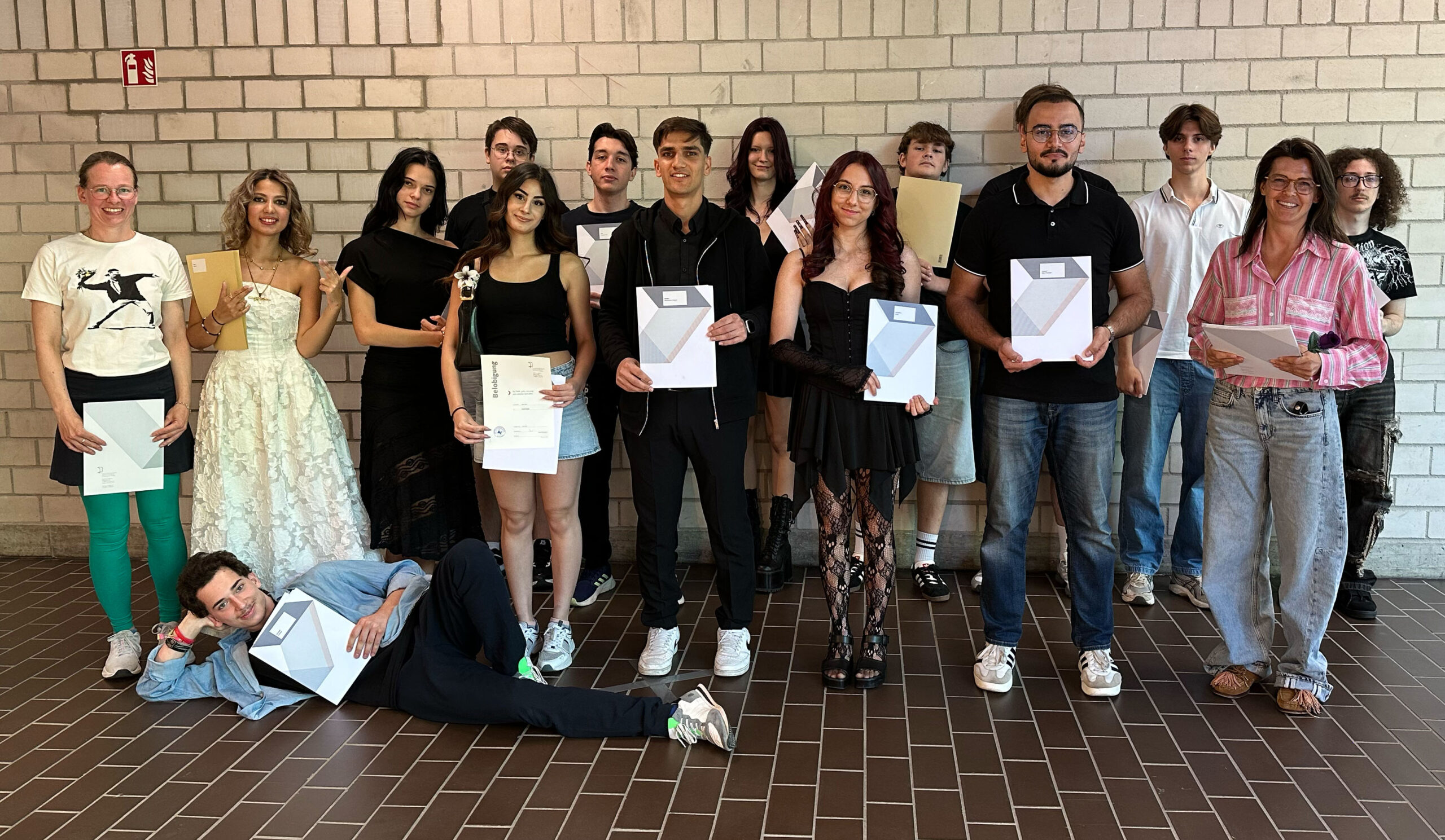 Auf dem Foto sind die diesjährigen Absolvent:innen der AV Dual 2 und ihre Klassenlehrerin Jessica El Menshawi zu sehen.