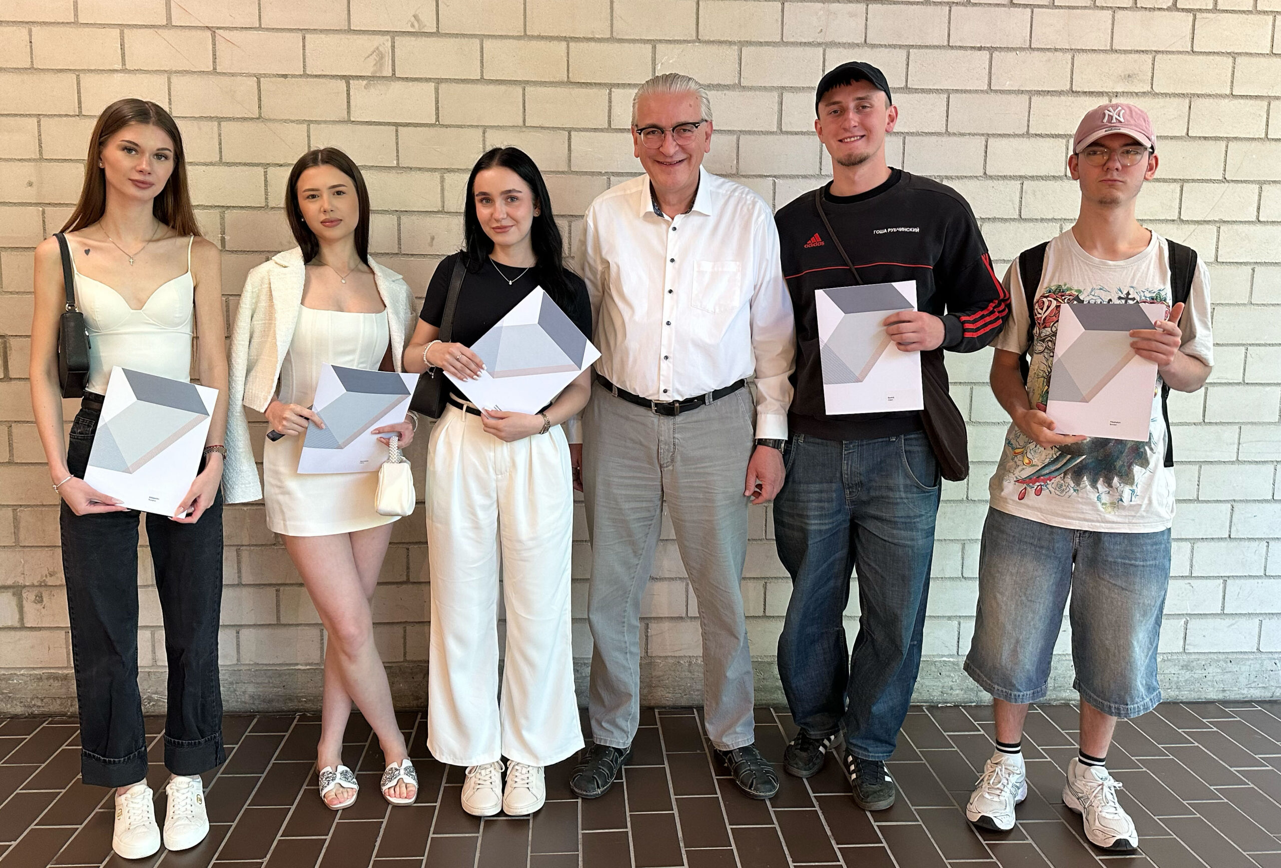 Auf dem Foto sind die fünf Absolvent:innen der BFFO sowie deren Klassenlehrer Peter Krepela zu sehen.
